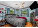 Cozy bedroom featuring a ceiling fan, two windows, and shelves with decorations at 428 Perdita Ave, Edgewater, FL 32132
