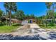 Single-story house with a blue front door, stone facade, and a driveway partially covered by a tarp at 428 Perdita Ave, Edgewater, FL 32132
