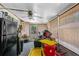 Enclosed sunroom featuring a refrigerator, ceiling fan, and window coverings at 428 Perdita Ave, Edgewater, FL 32132