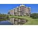 Upscale condo building with multiple balconies reflected in a pond on a sunny day at 4620 Riverwalk Village Ct # 7306, Ponce Inlet, FL 32127