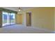 Bright living room featuring neutral carpet, ceiling fan, and balcony access at 4620 Riverwalk Village Ct # 7306, Ponce Inlet, FL 32127