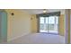 Bright living room with neutral carpet, ceiling fan, and sliding glass doors to a private balcony at 4620 Riverwalk Village Ct # 7306, Ponce Inlet, FL 32127