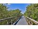 Scenic wooden walkway lined with lush greenery and a bright blue sky above, creating a serene nature path at 4620 Riverwalk Village Ct # 7306, Ponce Inlet, FL 32127