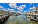 Scenic waterfront view showcasing boat docks and Harbour Village Beach Club condos under a partly cloudy sky at 4620 Riverwalk Village Ct # 7306, Ponce Inlet, FL 32127