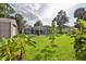 Expansive lawn with mature trees and screened-in pool area and additional seating at 475 Spruceview Dr, Port Orange, FL 32127