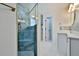 Modern bathroom features a glass-enclosed shower with blue marble-like tile, white marble floors, and a white vanity at 475 Spruceview Dr, Port Orange, FL 32127