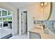 Bright bathroom with a quartz countertop vanity, mosaic tile accents, a door to storage, and a view of the outdoors at 475 Spruceview Dr, Port Orange, FL 32127