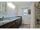 Bathroom with double sinks, framed mirrors, granite countertops, and tile shower at 475 Spruceview Dr, Port Orange, FL 32127
