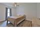 Sunlit bedroom with light wood-look tile flooring, ceiling fan, and side table at 475 Spruceview Dr, Port Orange, FL 32127