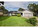 Charming single-story home featuring a manicured lawn, stone accents, and an attached two-car garage at 475 Spruceview Dr, Port Orange, FL 32127