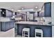 Modern kitchen featuring stainless steel appliances, an island with white stools, and sleek blue cabinetry at 475 Spruceview Dr, Port Orange, FL 32127