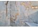 Close-up of an elegant shower with blue marble-like tile, a built-in bench, and bronze fixtures at 475 Spruceview Dr, Port Orange, FL 32127