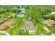 Aerial view of a home with a pool, tennis courts, and a serene lake nearby at 484 Sweet Bay Ave, New Smyrna Beach, FL 32168
