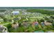 Aerial view of the property, with its pool, among lush trees and near tennis courts at 484 Sweet Bay Ave, New Smyrna Beach, FL 32168