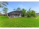 Spacious backyard showcasing a screened pool enclosure and well-manicured lawn, perfect for outdoor activities at 484 Sweet Bay Ave, New Smyrna Beach, FL 32168
