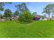 Well-kept backyard with lush green grass, a variety of trees, and a partial view of the home at 484 Sweet Bay Ave, New Smyrna Beach, FL 32168