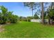 Expansive backyard featuring lush green grass and mature trees, offering privacy and tranquility at 484 Sweet Bay Ave, New Smyrna Beach, FL 32168