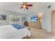 Comfortable bedroom with a ceiling fan, neutral carpet, and a dresser with television at 484 Sweet Bay Ave, New Smyrna Beach, FL 32168