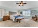 Bright primary bedroom with ceiling fan, light colored walls, and an upholstered bench at 484 Sweet Bay Ave, New Smyrna Beach, FL 32168