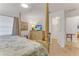 Well lit bedroom with a four poster bed, ceiling fan, dresser and an en-suite bathroom at 484 Sweet Bay Ave, New Smyrna Beach, FL 32168