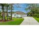 Charming one-story home featuring a well-manicured front lawn, a long driveway, and a three car garage at 484 Sweet Bay Ave, New Smyrna Beach, FL 32168