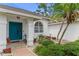 Attractive front entrance with a bright teal door, tiled porch, and manicured landscaping at 484 Sweet Bay Ave, New Smyrna Beach, FL 32168