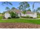 Charming single-story home with lush landscaping, vibrant green lawn, and a welcoming walkway at 484 Sweet Bay Ave, New Smyrna Beach, FL 32168