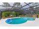 Large screened-in pool with blue water and an inflatable float; view of backyard at 484 Sweet Bay Ave, New Smyrna Beach, FL 32168