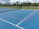 Outdoor community tennis court with well-maintained playing surface and surrounding landscaping at 4849 Saxon # C202, New Smyrna Beach, FL 32169