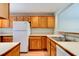 A bright kitchen featuring wooden cabinets, white countertops, and modern appliances at 488 Shorewood Ln, New Smyrna Beach, FL 32168