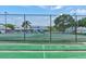 Well-maintained tennis courts enclosed by fencing, alongside a shuffleboard court for recreational enjoyment at 488 Shorewood Ln, New Smyrna Beach, FL 32168