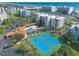 A sunny aerial view of condos near tennis courts, pool, Intracoastal Waterway, and the beach at 5300 S Atlantic Ave # 1-603, New Smyrna Beach, FL 32169