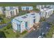 A sunny aerial view of a multi-story building with a parking lot surrounded by lush landscaping at 5300 S Atlantic Ave # 1-603, New Smyrna Beach, FL 32169