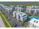 A sunny aerial view of a condo complex near tennis courts and a lake with lush landscaping at 5300 S Atlantic Ave # 1-603, New Smyrna Beach, FL 32169