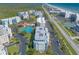 A sunny aerial view of multi-story condos near beach, Intracoastal Waterway, pool, and tennis courts at 5300 S Atlantic Ave # 1-603, New Smyrna Beach, FL 32169