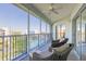 Screened-in balcony with seating and views of the surrounding community and landscaping at 5300 S Atlantic Ave # 1-603, New Smyrna Beach, FL 32169