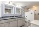 This bathroom features white tiling, double sinks, a granite countertop, and framed mirrors at 5300 S Atlantic Ave # 1-603, New Smyrna Beach, FL 32169