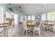 Well-lit common room with tables and chairs with a view into the kitchen area at 5300 S Atlantic Ave # 1-603, New Smyrna Beach, FL 32169