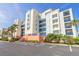 Bright multi-story condo building featuring colorful accents, well-maintained landscaping, and ample parking at 5300 S Atlantic Ave # 1-603, New Smyrna Beach, FL 32169