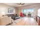 Bright living room with hardwood floors, neutral paint, comfortable seating and a sliding glass door to the balcony at 5300 S Atlantic Ave # 1-603, New Smyrna Beach, FL 32169