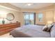 This well lit main bedroom features a ceiling fan, private balcony, and neutral color palette at 5300 S Atlantic Ave # 1-603, New Smyrna Beach, FL 32169