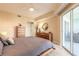 This bedroom features a ceiling fan, private balcony with seating, and lots of storage at 5300 S Atlantic Ave # 1-603, New Smyrna Beach, FL 32169