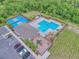 Beautiful aerial view of community pool, playground, tennis courts, and parking spaces for convenient access at 534 Stowers Dr, New Smyrna Beach, FL 32168
