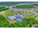 Aerial view showcases community amenities: pool, cabana, pickleball courts and parking area with lush surroundings at 534 Stowers Dr, New Smyrna Beach, FL 32168