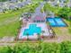 Aerial view showcasing the community pool, playground, and tennis courts surrounded by palm trees at 534 Stowers Dr, New Smyrna Beach, FL 32168