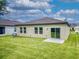 Spacious backyard featuring lush green lawn, sliding glass door access and views of neighboring properties at 534 Stowers Dr, New Smyrna Beach, FL 32168