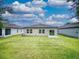 Expansive backyard with well-maintained lawn and views of adjacent homes under a cloudy sky at 534 Stowers Dr, New Smyrna Beach, FL 32168