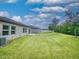 Wide backyard featuring a lush lawn, views of neighboring properties and a tree lined perimeter at 534 Stowers Dr, New Smyrna Beach, FL 32168