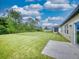 Backyard with a concrete patio and abundant green space for outdoor activities at 534 Stowers Dr, New Smyrna Beach, FL 32168