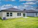 View of the home's backyard, showcasing a grassy lawn, concrete patio, and exterior features at 534 Stowers Dr, New Smyrna Beach, FL 32168